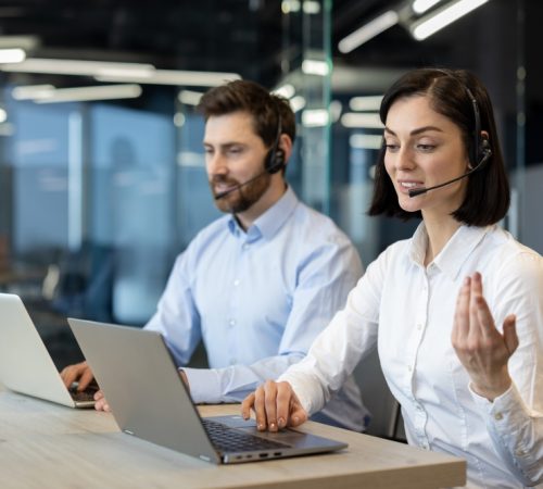 Customer,Service,Agents,In,Office,Using,Laptops,And,Headsets,,Demonstrating